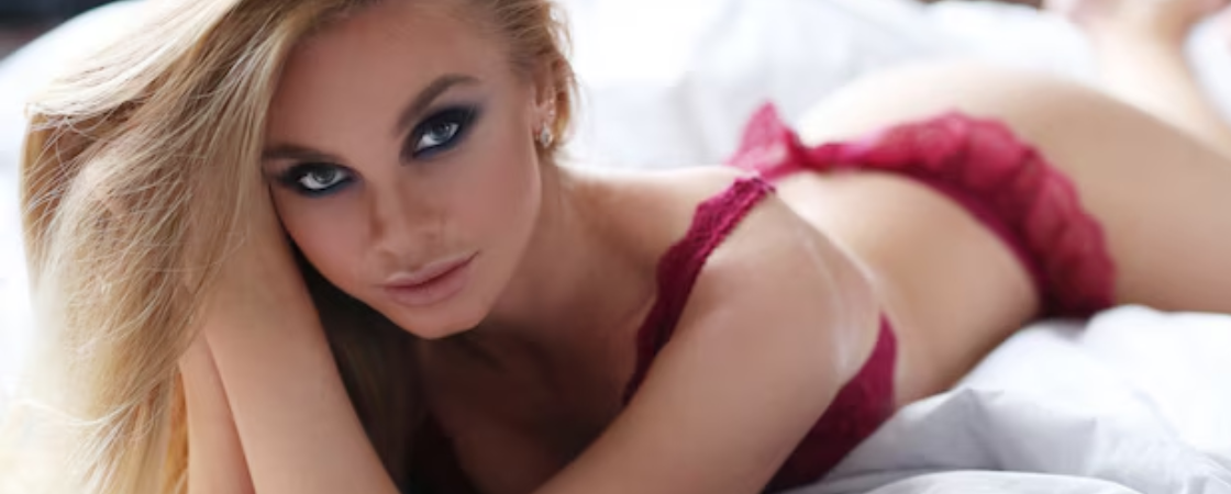 A Wolverhampton Escort lay on the bed in pink lingerie
