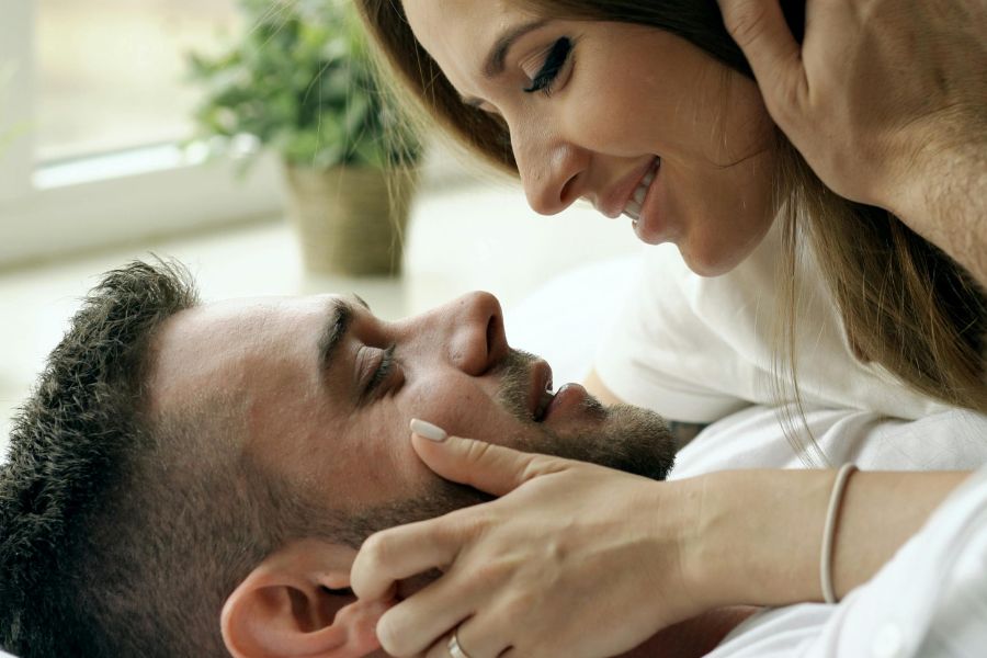 Couple sharing intimate moment in bed representing girlfriend experience